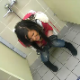 A girl pees in a urinal because her friend is using the only other toilet.